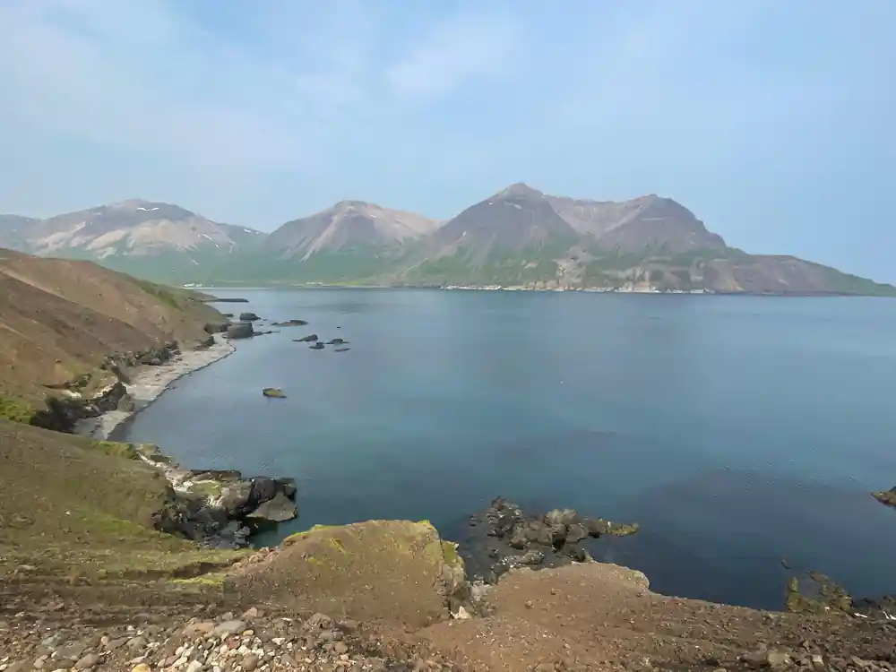 Mountains surrounding calm blue lake with rocky shore
