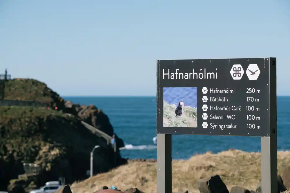 Signpost at coastal viewpoint with sea and cliffs
