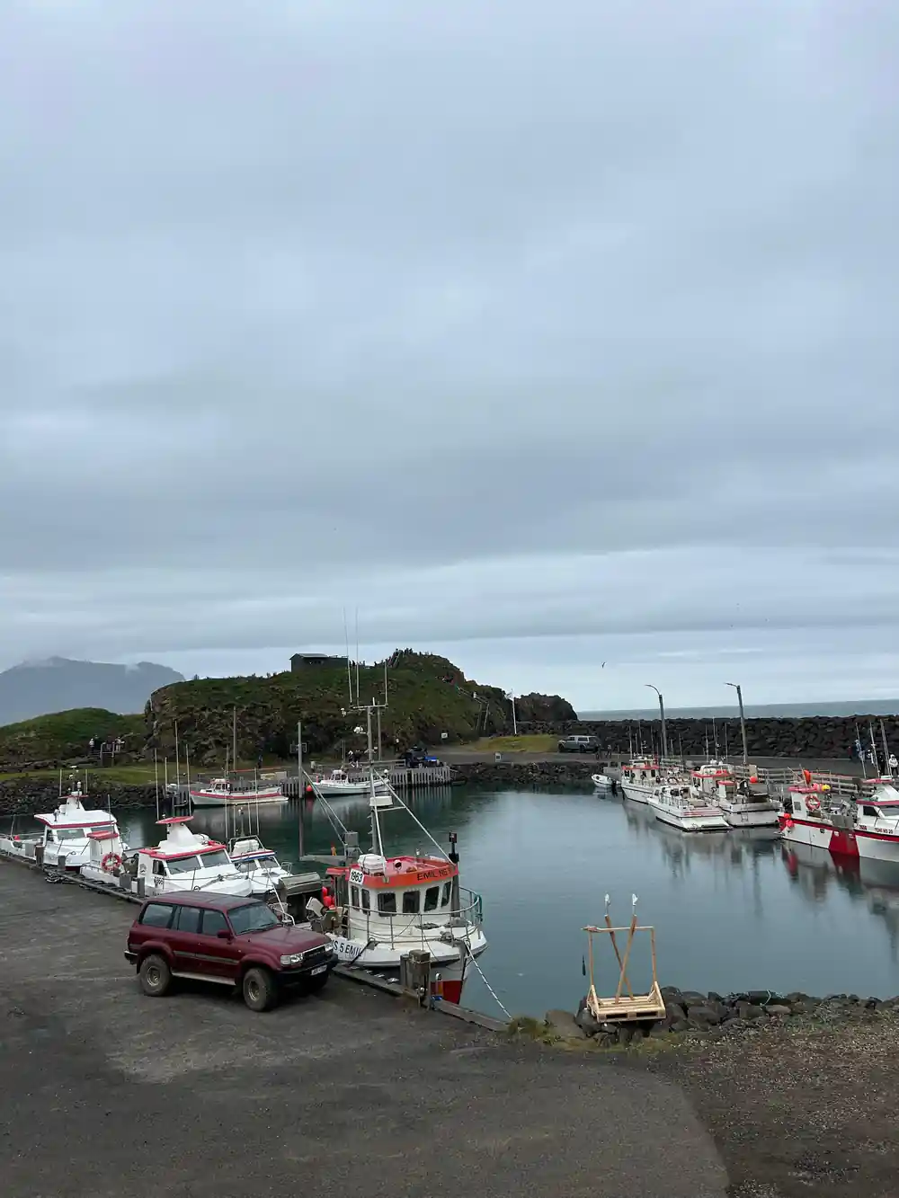 Small fishing harbor with red and white boats moored